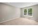 Cozy bedroom with soft carpet flooring and windows offering views of green trees outside at 106 Cherry Glen Way, Euharlee, GA 30145