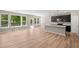 Bright, open living space with a kitchen featuring dark cabinets and plenty of natural light from large windows at 106 Cherry Glen Way, Euharlee, GA 30145