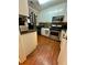 Galley kitchen with white cabinets, stainless steel appliances, and wood flooring at 710 River Run Dr, Atlanta, GA 30350