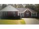 Brick ranch home with landscaped yard and driveway at 155 Vinnys Way, Covington, GA 30014