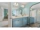 Double vanity bathroom with a large mirror and light blue cabinets at 413 Brooch Way, Stockbridge, GA 30281