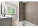 Updated bathroom with gray tile, a new vanity and a bathtub at 1507 Lively Ridge Ne Rd, Atlanta, GA 30329