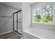 Spa-like bathroom with glass-enclosed shower, soaking tub, and a large window offering nature views at 126 Cherry Glen Way, Euharlee, GA 30145