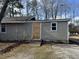 Beige house with boarded-up door and window, needs repairs at 3965 Pecan Rd, Loganville, GA 30052
