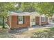 Brick ranch house with a covered porch and well-maintained lawn at 895 Kings Grant Nw Dr, Atlanta, GA 30318