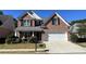 Brick two-story house with a white garage door and landscaping at 2280 Hickory Station Cir, Snellville, GA 30078