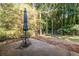 Small patio with table and umbrella, wooded backyard at 2849 Crescendo Nw Dr, Atlanta, GA 30318