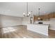 Modern kitchen featuring an island with sink, stainless appliances, wood cabinetry, and stylish pendant lights at 123 Cherry Glen Way, Euharlee, GA 30145