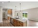 Kitchen island with stainless dishwasher and sink, pendant lighting, and sliding door leading to outdoor space at 123 Cherry Glen Way, Euharlee, GA 30145