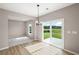 Bright living room with a sliding glass door to the backyard and a modern chandelier over the dining area at 123 Cherry Glen Way, Euharlee, GA 30145