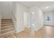 Bright entryway features wood-look flooring, carpeted stairs and a view to the front door and bedroom at 1482 Stephens View Dr, Loganville, GA 30052