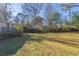Sunny backyard with a large grassy area and trees at 2599 Browns Mill Se Rd, Atlanta, GA 30354