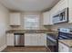 Renovated kitchen with white cabinets, granite countertops, and stainless steel appliances at 2599 Browns Mill Se Rd, Atlanta, GA 30354