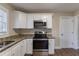 Modern kitchen featuring white cabinets, granite counters, and stainless steel appliances at 2599 Browns Mill Se Rd, Atlanta, GA 30354
