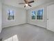 Large bedroom with plush carpeting, ceiling fan, and abundant natural light from two windows at 555 Bridge Ave, Forest Park, GA 30297