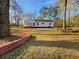 Charming single-story home with a red brick foundation and a screened-in porch, nestled on a spacious lot at 555 Bridge Ave, Forest Park, GA 30297