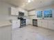 Modern kitchen with stainless steel appliances, white cabinets, and marbled tile floors at 555 Bridge Ave, Forest Park, GA 30297
