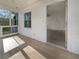 Bright sunroom featuring wood floors, multiple windows, and an entry door to the main house at 555 Bridge Ave, Forest Park, GA 30297