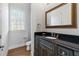 Modern bathroom with dark vanity, granite countertop, and a large mirror at 3352 Forest Vista Dr, Dacula, GA 30019