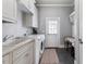 Bright laundry room with washer, dryer, and built-in cabinets at 3352 Forest Vista Dr, Dacula, GA 30019