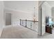 Spacious upper hallway with plush carpeting, elegant chandelier, and access to other rooms at 3352 Forest Vista Dr, Dacula, GA 30019