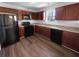 Kitchen with dark wood cabinets, black appliances, and vinyl flooring at 5165 Hanover St, Atlanta, GA 30349