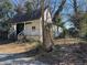 Exterior of a run-down, one-story house with a wooden porch and overgrown landscaping at 125 Martin Se Ave, Atlanta, GA 30315