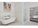 Bright bathroom with white, free-standing tub and glass-enclosed shower adjacent to the primary bedroom at 6725 Cross Gate St, Cumming, GA 30040