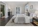 Bright bedroom with a white bed, bench, and a view of the adjacent mud room and patio at 6725 Cross Gate St, Cumming, GA 30040