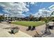 A charming town green featuring an open lawn, ample seating, and decorative landscaping under a bright, partly cloudy sky at 6725 Cross Gate St, Cumming, GA 30040