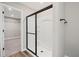Modern bathroom featuring a glass-enclosed shower with dark hardware and a glimpse into the walk-in closet at 1002 Rainier Dr, Euharlee, GA 30145