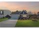 Charming single-story home with a well-manicured lawn and attached two car garage at dusk at 1002 Rainier Dr, Euharlee, GA 30145