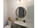 Small bathroom with pedestal sink and round mirror at 301 Rexmere Rd, Mcdonough, GA 30252