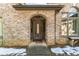 Arched entryway with a wooden door, brick facade, and snow on the ground at 570 Pleasant Grove Rd, Mcdonough, GA 30252