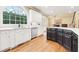 White kitchen with center island, stainless steel appliances and hardwood floors at 206 Woodridge Pkwy, Canton, GA 30115
