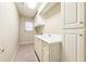 Bright laundry room with ample cabinetry and a double sink at 206 Woodridge Pkwy, Canton, GA 30115