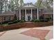 Stately brick home with white columns, dark shutters, and professionally landscaped front yard at 1120 Heards Ferry Rd, Sandy Springs, GA 30328