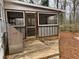 Covered back porch with wooden deck, screened enclosure, and view of wooded backyard at 240 Dogwood Dr, Canton, GA 30114