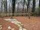 Spacious backyard with a patio, fire pit, and wooden fence surrounded by mature trees at 240 Dogwood Dr, Canton, GA 30114