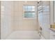 Bright bathroom with a window, tiled walls, and a sleek, modern bathtub at 240 Dogwood Dr, Canton, GA 30114