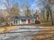 Charming home featuring a bright red front door, white siding, a metal roof and an extended gravel driveway at 240 Dogwood Dr, Canton, GA 30114