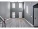 Two-story living room with gray walls, hardwood floors, and multiple windows at 6269 Colonial Vw, Fairburn, GA 30213