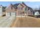 Brick two-story house with a three-car garage and landscaping at 3356 Renfro St, Marietta, GA 30066