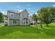 Spacious backyard with lush lawn, mature trees, patio and a two-story home in the background at 4450 Millenium View Ct, Snellville, GA 30039