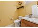 Cozy half bathroom with a vanity, toilet, and decorative shelf at 4450 Millenium View Ct, Snellville, GA 30039