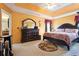 Large main bedroom with dark wood furniture and orange walls at 4450 Millenium View Ct, Snellville, GA 30039
