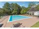 Community pool surrounded by lounge chairs and mature trees, perfect for relaxation at 4450 Millenium View Ct, Snellville, GA 30039