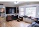Spacious living room with a large TV, built-in seating, and hardwood floors at 1400 New Hope Church Rd, Loganville, GA 30052