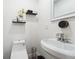 Modern bathroom with pedestal sink, toilet and floating shelves at 2082 Perkerson Sw Rd, Atlanta, GA 30310