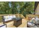 Relaxing deck with seating area, fire pit table, and wooded backdrop at 2082 Perkerson Sw Rd, Atlanta, GA 30310